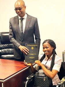 Melody Omosah, Esq., Executive Director of NAPVID, receives the project dissertation of Kindness Idahosa, marking her graduation from the Faculty of Law, University of Benin.