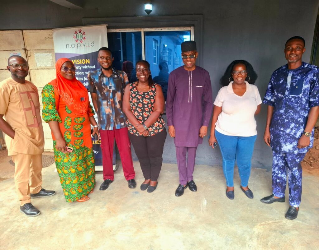NAPVID staff and SONKE representatives pose for a group photograph outside the organisation’s secretariat in Benin City, Edo State, in front of a NAPVID banner.
